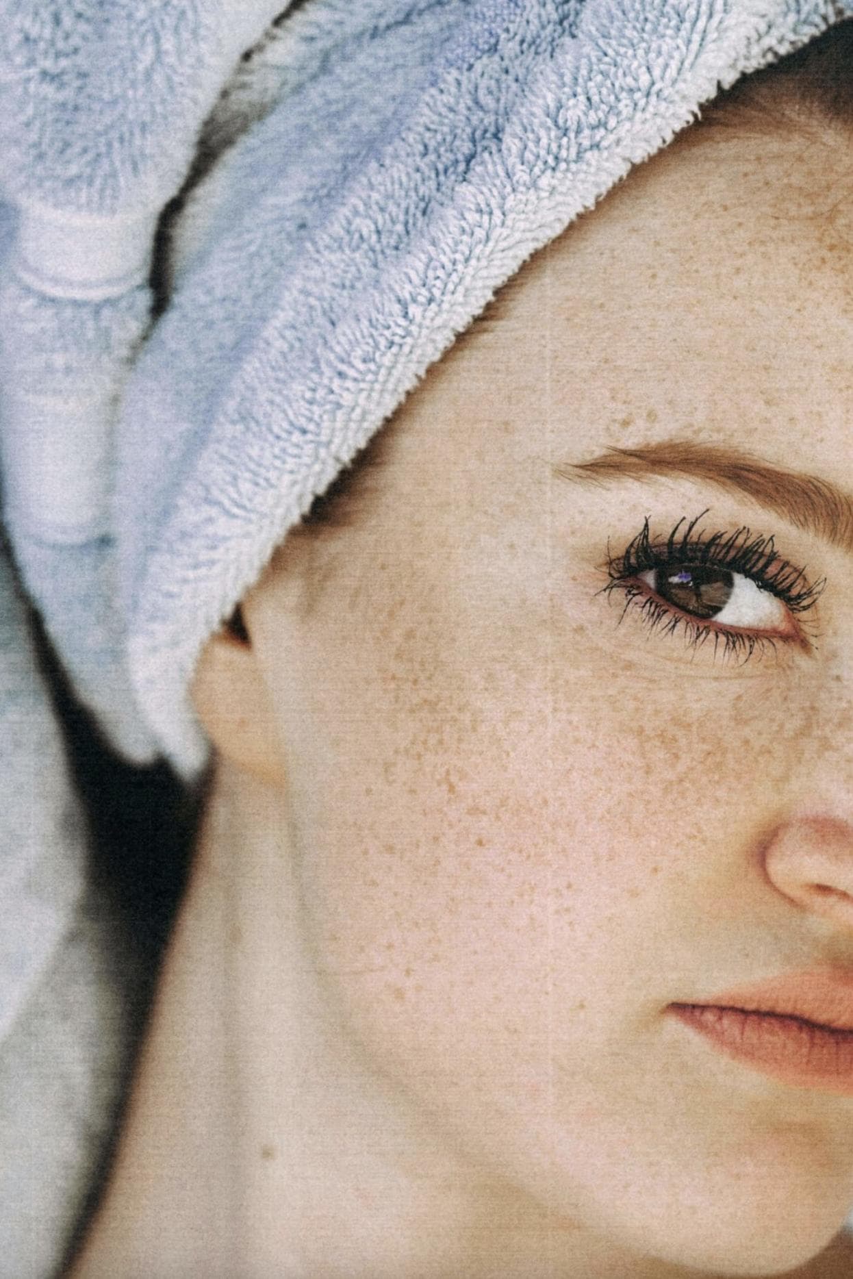 Woman with freshly washed hair in a towel half face