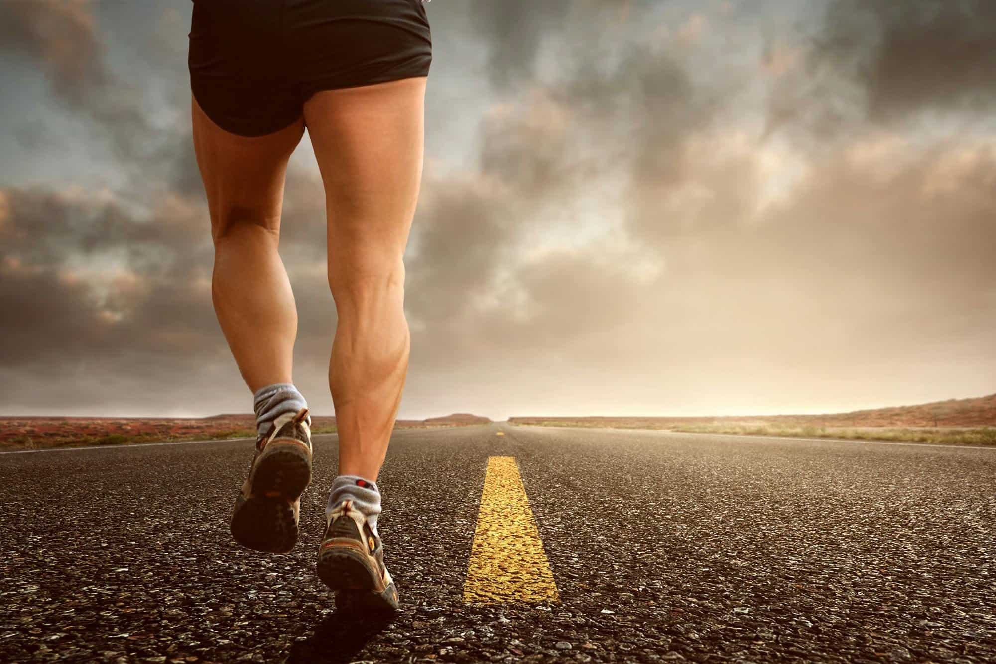 calves of a man running on the road
